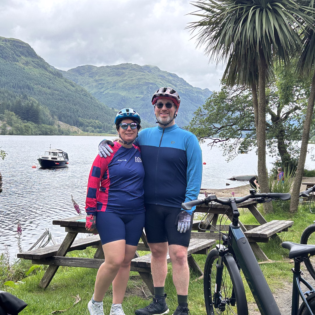 Two cyclists posing in front of Loch Eck 
